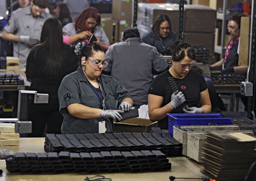 FILE - In this Feb. 28, 2013 file photo, workers assemble 30-round capacity ammunition magazines for high-velocity rifles, inside the Magpul Industries plant in Erie, Colo. Magpul, one of the country's largest producers of ammunition magazines for guns, is leaving Colorado and moving operations to Wyoming because of Colorado laws that include restrictions on how many cartridges a magazine can hold. The Wyoming State Loan and Investment Board is considering a $13 million incentive package to help Magpul make the move. (AP Photo/Brennan Linsley, File)