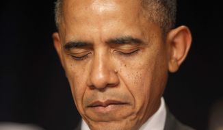 President Barack Obama closes his eyes as a prayer is offered at the National Prayer Breakfast in Washington, Thursday, Feb. 6, 2014. (AP Photo/Charles Dharapak)