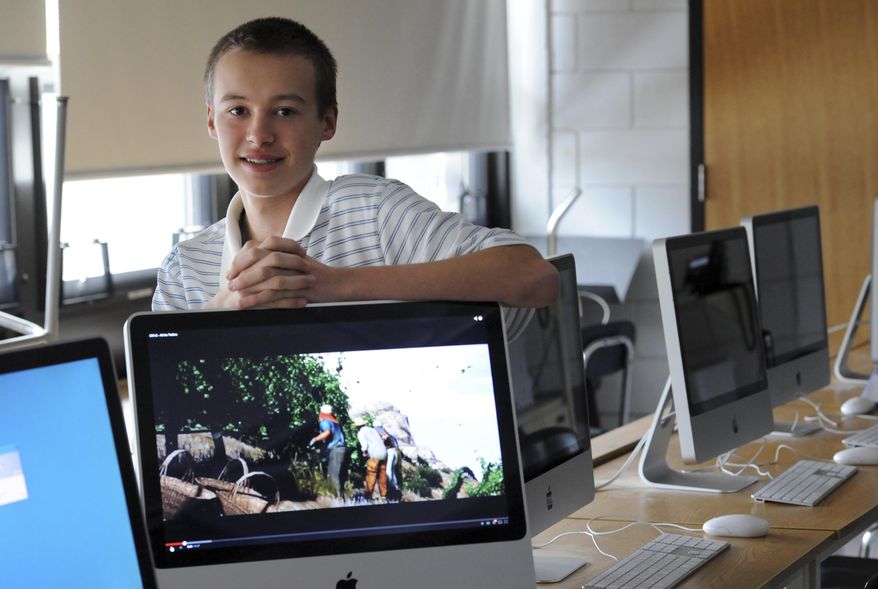 FOR USE IN WEEKEND EDITIONS FEB. 8-9 - In this Jan. 27, 2014 photo, Matt West poses among computers at Nauset Regional High School in North Eastham, Mass. In an effort to keep children younger than himself away from violent video games, West has started a club to design and market nonviolent games. (AP Photo/Cape Cod Times, Merrily Cassidy) MANDATORY CREDIT. INTERNET OUT. MAGS OUT. TV OUT. NO ARCHIVING WITHOUT PERMISSION.