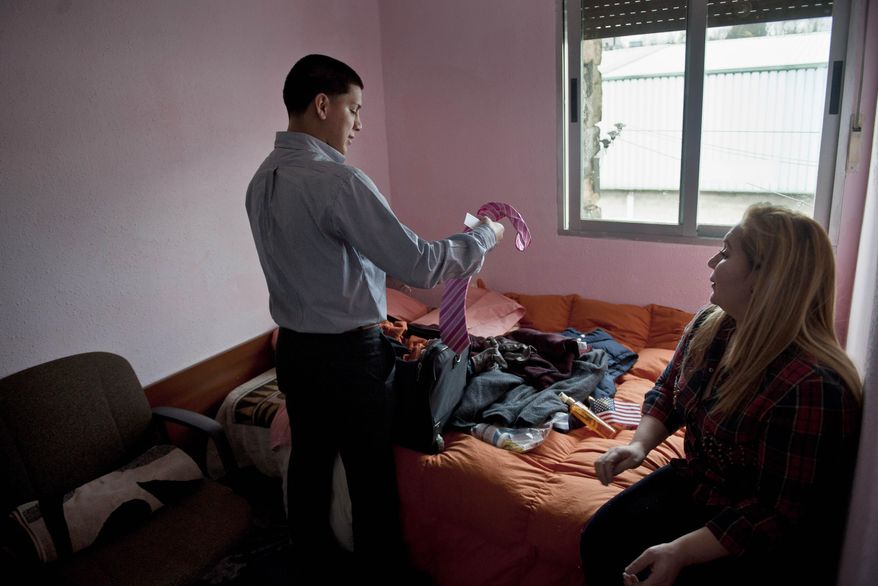 In this Wednesday, Dec. 25, 2013 photo, Melba Soza sits next to her son Jose Antonio as he unpacks his luggage in an apartment in Basauri, Spain. They had five days together, spent seeing the sites of Bilbao and taking in a movie and catching up on time missed. She told him she worried that she’d been a disappointment: "I feel ... like I have failed as a mother for being deported." But Jose reassured her. "My mother has gone through a storm, but she doesn’t lose sight of the sun," he said. (AP Photo/Alvaro Barrientos)