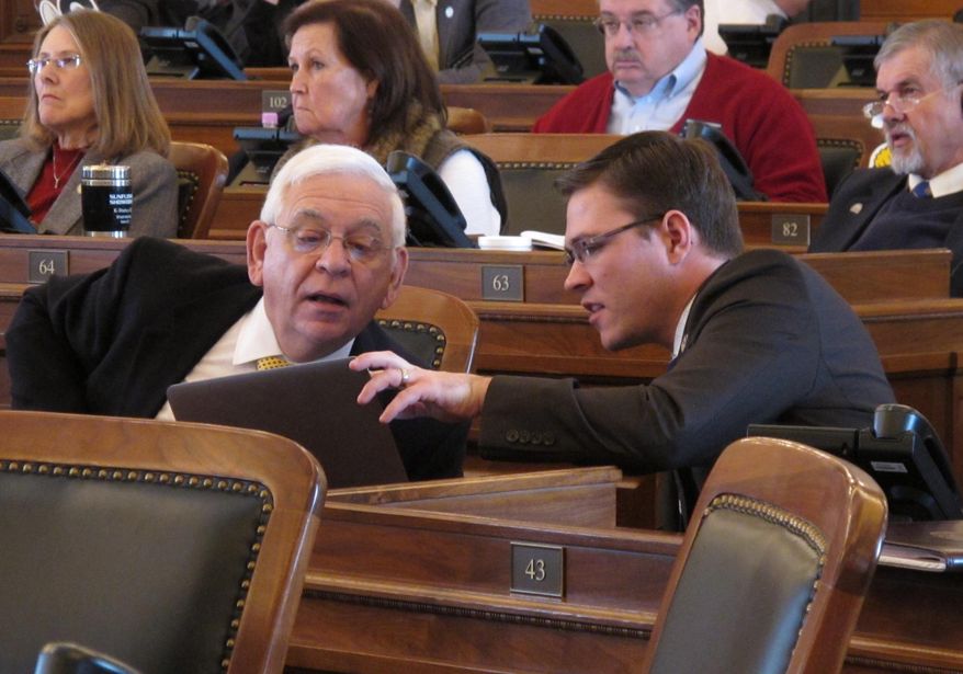 Kansas state Reps. John Rubin, left, a Shawnee Republican, and Joshua Powell, right, a Topeka Republican, confer as the House debates a bill easing restrictions on the home brewing of beer, wine and cider, Friday, Feb. 7, 2014, at the Statehouse in Topeka, Kan. Kansas law currently does not allow home brewers to share their products. (AP Photo/John Hanna)