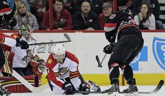 Carolina Hurricanes&#39; Riley Nash (20) shoots against  Florida Panthers&#39; Dmitry Kulikov (7), of Russia, and goalie Tim Thomas during the first period of an NHL hockey game in Raleigh, N.C., Friday, Feb. 7, 2014. Nash scored on the shot. (AP Photo/Gerry Broome)