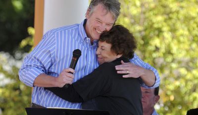 In this photo taken on Sept. 21, 2013, Illinois state Rep. John Bradley, D-Marion, hugs Louise Harrison, the sister of late Beatles guitarist George Harrison, after reading a proclamation during the unveiling of a historical marker honoring the musician&#39;s visit to Benton, Ill., 50 years earlier to visit his sister. George Harrison&#39;s two-week vacation in Illinois made him the first Beatle to come to the United States and was five months before the group&#39;s landmark live appearance on &amp;quot;The Ed Sullivan Show&amp;quot; launched the British invasion. Harrison and the Beatles were virtually unknown in America, explaining why he enjoyed anonymity in 7,000-resident Benton. (AP Photo/The Southern, Paul Newton)