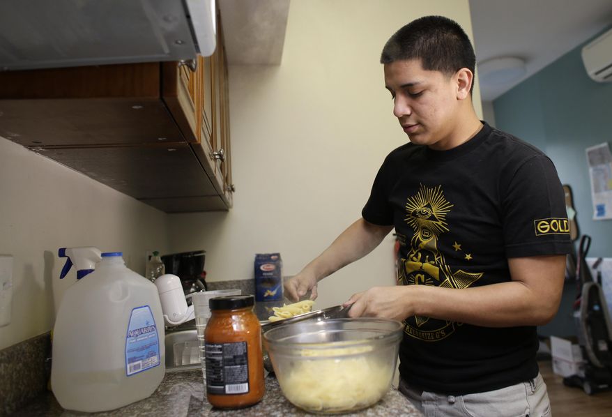 In this Friday, Jan. 10, 2014 photo, Jose Antonio Machado cooks pasta at his home in Miami. "Jose is an abandoned child," a child law advocate wrote in the court papers that led to his placement in a foster home back in 2011. At least 5,100 children whose parents are either in detention, or already deported, live in foster care today, according to one estimate. (AP Photo/Lynne Sladky)