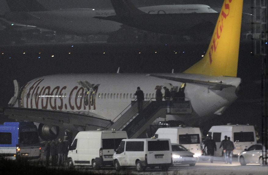 Passengers of private Turkish company Pegasus leave the plane at the Sabiha Gokcen Airport in Istanbul, Turkey, Friday, Feb. 7, 2014. An official says authorities have subdued a man who attempted to hijack a Turkish plane to Sochi, Russia, and that the other passengers have been evacuated. Huseyin Avni Mutlu, the Istanbul governor, says on Twitter that "the operation has ended." In another tweet Friday, he said all passengers were evacuated "without any problems."(AP Photo/Emrah Gurel)