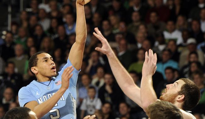 North Carolina guard Marcus Paige, left, puts up a shot over Notre Dame forward Garrick Sherman during the second half of an NCAA college basketball game Saturday, Feb. 8, 2014, in South Bend, Ind. (AP Photo/Joe Raymond)