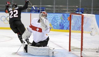 Goalkeeper Florence Schelling of Switzerland looks back at the puck in the net as Hayley Wickenheiser of Canada celebrates her goal during the second period of the women&#39;s ice hockey game at the Shayba Arena during the 2014 Winter Olympics, Saturday, Feb. 8, 2014, in Sochi, Russia. (AP Photo/Matt Slocum)