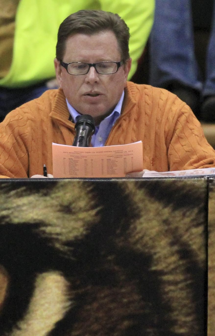 ADVANCE FOR SATURDAY FEB. 8 AND THEREAFTER - In a Jan. 28, 2014 photo, Rick Klamm, executive vice president at Heritage Insurance in Wood River, makes an announcement at the beginning of the Hastings High/Adams Central girls basketball game at Hastings High in Hastings, Neb. Klamm is the voice of the Tigers during football and basketball season. (AP Photo/Hastings Tribune, Laura Beahm)