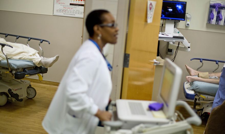 In this Friday, Jan. 24, 2014, file photo, patients lie on beds in exam rooms as EKG Technician Gwendolyn Freeman makes her rounds at Grady Memorial Hospital, in Atlanta. (AP Photo/David Goldman) **FILE**