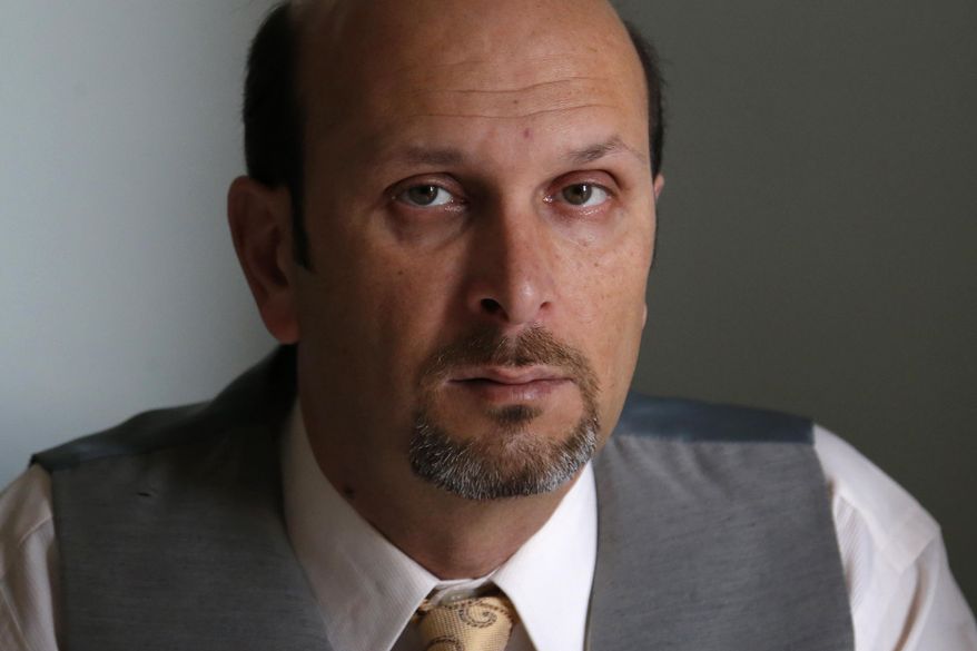This photo taken Feb. 7, 2014 shows real estate agent Morteza Assadi, 49, in his home in Vienna, Va., Friday, Feb. 7, 2014. The Obama administration has eased the rules for would-be asylum seekers, refugees and others who hope to come to the United States or stay here and who gave ``limited” support to terrorists or terrorist groups. For Assadi, the law has left him in a sort of immigration purgatory while his green card application has been on hold for more than a decade. (AP Photo/Charles Dharapak)
