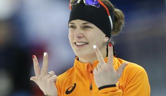 Ireen Wust of the Netherlands flashes three fingers in each hand, indicating her third olympic gold medal, after winning gold in the women&#39;s 3,000-meter speedskating race at the Adler Arena Skating Center during the 2014 Winter Olympics, Sunday, Feb. 9, 2014, in Sochi, Russia.  (AP Photo/Matt Dunham)
