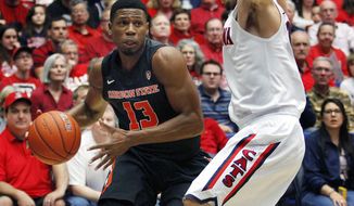Oregon State&#39;s Langston Morris-Walker (13) dribbles around the defense of Arizona&#39;s Gabe York, right, in the first half of an NCAA college basketball game on Sunday, Feb. 9, 2014, in Tucson, Ariz. (AP Photo/John MIller)