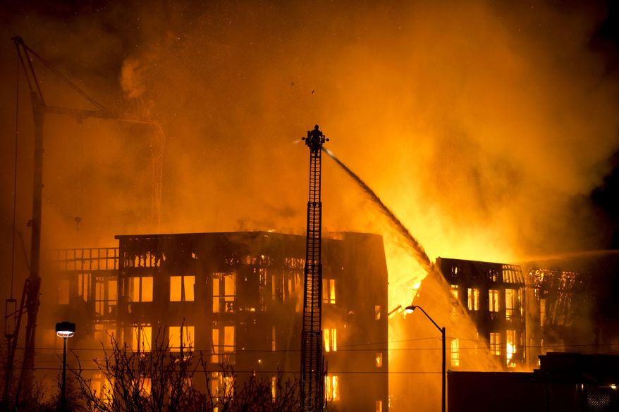 Firefighters battle an apartment fire in Salt Lake City, Sunday, Feb. 9, 2014. The apartment building that was under construction. Agency spokesman Jasen Asay told The Associated Press that the Fire Department did a walkthrough of the building on Saturday. (AP Photo/The Salt Lake Tribune, Lennie Mahler)