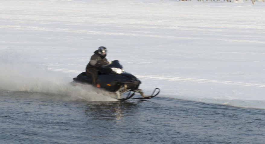 In a photo provided by the Michigan Department of Natural Resources authorities said a duck can be seen on the right ski of a snowmobile as it travels through an area of open water on the Saginaw River in Bay City, Mich., late Saturday afternoon, Feb. 8, 2014. Officials are searching for two snowmobilers they say rode through the open water killing several ducks. (AP Photo/Michigan Department of Natural Resources via The Bay City Times) Photo Courtesy Michigan DNR