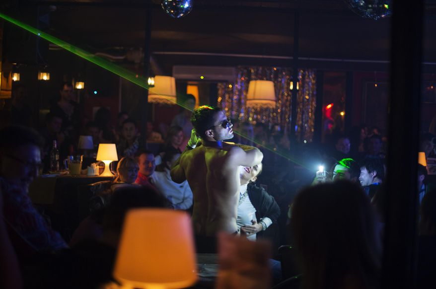 In this photo taken Saturday, Feb. 8, 2014, a dancer performs in the crowd at the Mayak cabaret, the most reputable gay club in Sochi, Russia, host to 2014 Winter Olympics. Russia adopted a law last year, prohibiting vaguely defined propaganda of non-traditional sexual relations and pedophilia. The legislation makes it illegal to disseminate information to children even if it merely shows that gay people are just like everybody else. At Mayak, packed on Saturday night, gay men and women steered away from discussing the law, preferring to enjoy life, closeted as it is. About a hundred people were chatting at the bar, sitting in armchairs or dancing. Couples were sharing kisses. Everyone was waiting for the club's specialty: a drag show. At 1.30 a.m. on Sunday, the music stopped and the show began. (AP Photo/David Goldman)