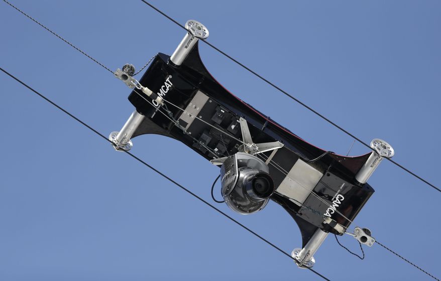 A spider camera records the nordic combined training in the ski jumping stadium at the 2014 Winter Olympics, Monday, Feb. 10, 2014, in Krasnaya Polyana, Russia. (AP Photo/Matthias Schrader)