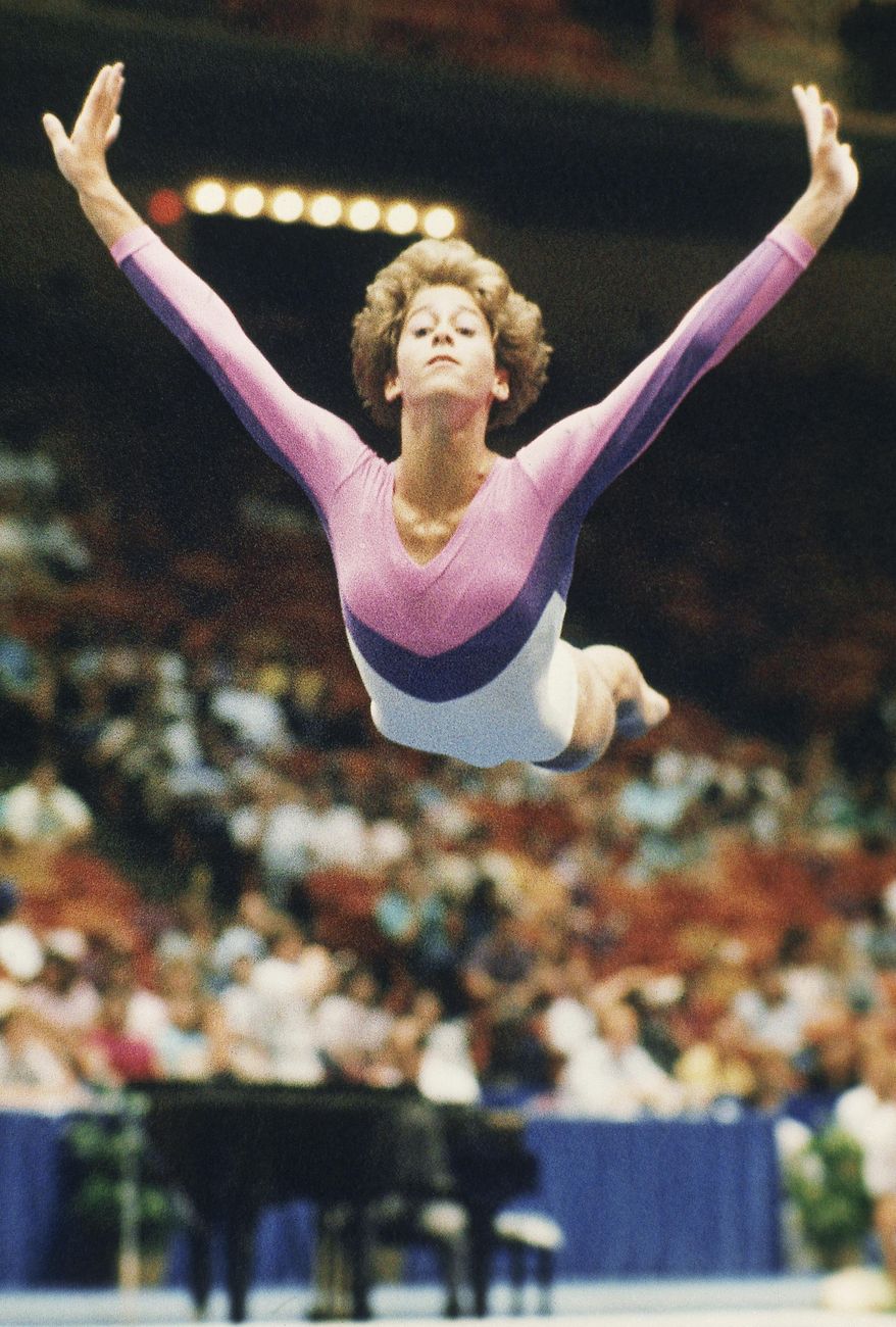 FILE - In this July 1988 file photo, U.S. gymnast Phoebe Mills flies through the air as she performs her floor exercise at the U.S. Gymnastics Championships in Houston, Texas. Mills used to flip for Olympic medals. These days, she decides who wins them. The 1988 U.S. gymnastics champion and Olympic bronze medalist is working in the snowboarding judging booth at the Sochi Games, giving marks in both the halfpipe and slopestyle contests at Rosa Khutor Extreme Park.  (AP Photo/David Breslauer, File)