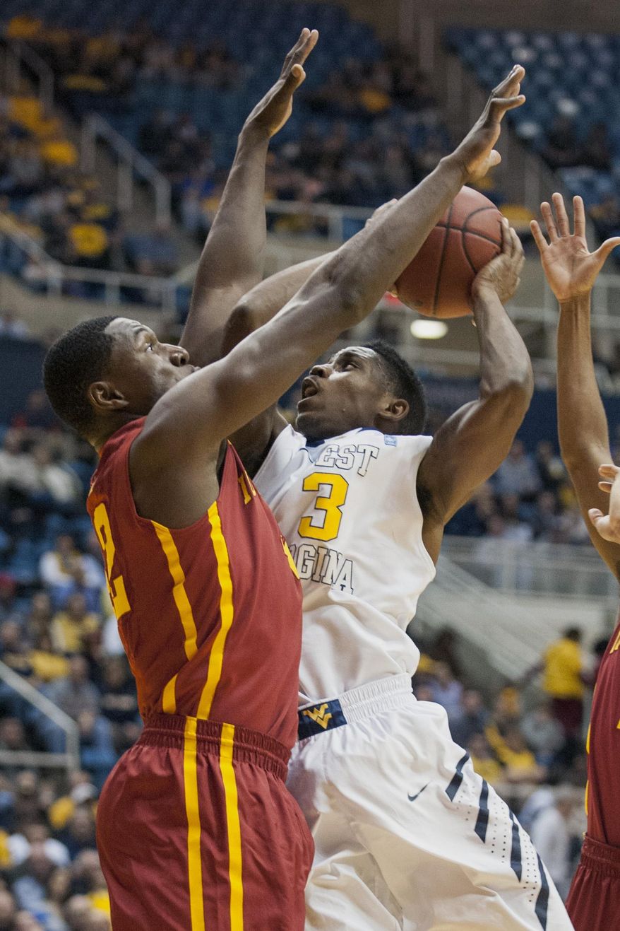 West Virginia's Juwan Staten (3) drives to the basket as Iowa State's Daniel Edozie defends during the second half of an NCAA college basketball game, Monday, Feb. 10, 2014, in Morgantown, W.Va. West Virginia won 102-77. (AP Photo/Andrew Ferguson)