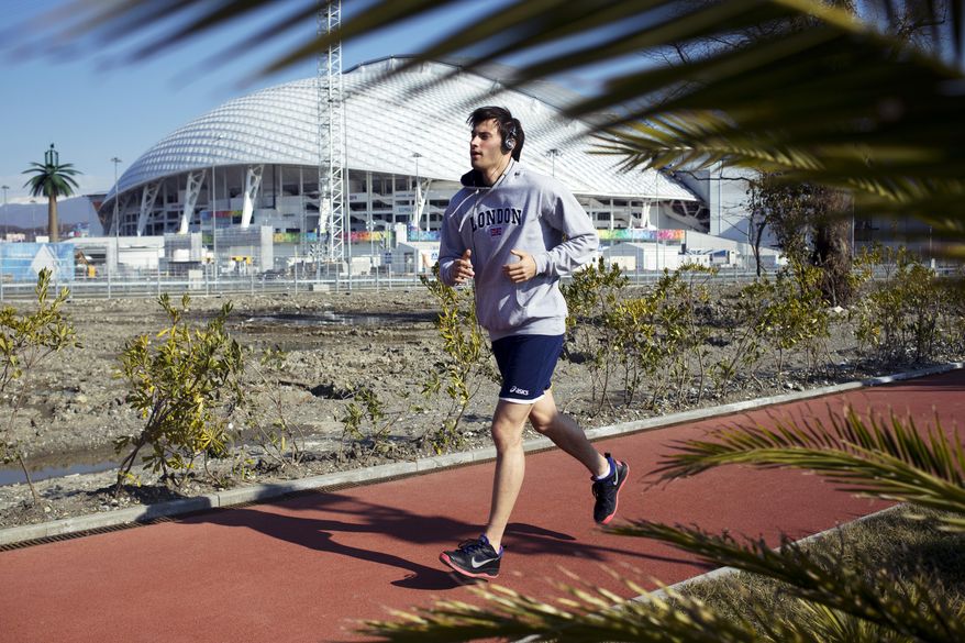A man runs at a boardwalk near the Fisht Olympic Stadium in Olympic Park during the 2014 Winter Olympics, Monday, Feb. 10, 2014, in Sochi, Russia. (AP Photo/Pavel Golovkin)