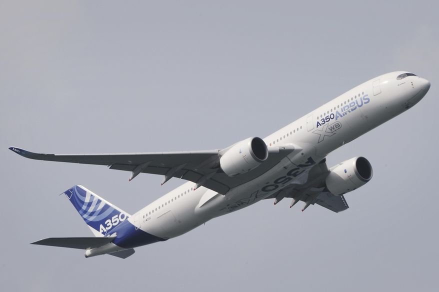 An Airbus A350-900 flies during an aerial display for a media preview ahead of the upcoming Singapore Air Show on Sunday, Feb. 9, 2014.  (AP Photo/Joseph Nair)