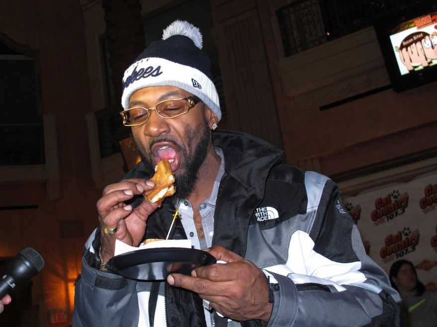 James Sanders, of New York, eats a variety of bacon sandwich during the Bacon Week festival Monday, Feb. 10, 2014 at the Tropicana Casino and resort in Atlantic City, N.J. The casino's Bacon Week festival includes unusual offerings like bacon milk shakes, bacon cupcakes, bacon bloody Marys, beer, vodka and bourbon, and even bacon-flavored toothpaste, dental floss and lip balm. (AP Photo/Wayne Parry)