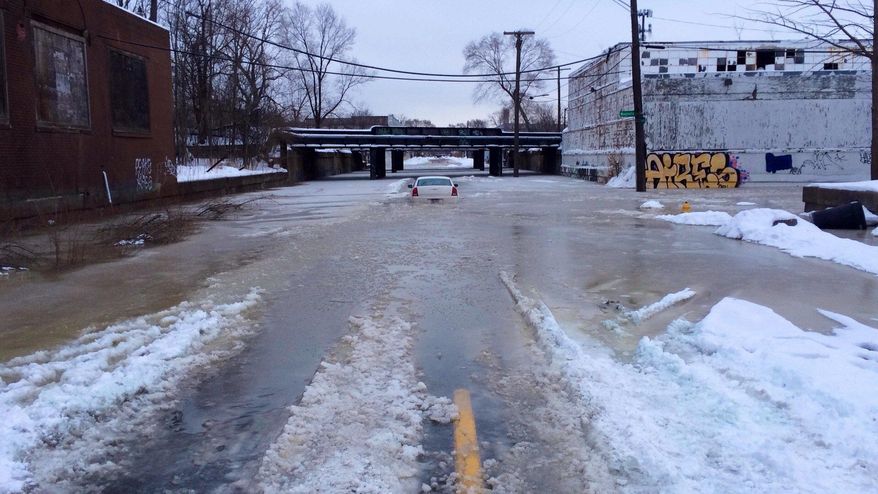 A car is surrounded by water on a flooded street after a water main break in Detroit on Tuesday, Feb. 11, 2014. The broken water main flooded a several-block area in southwest Detroit, trapping several cars. (AP Photo/Detroit Free Press, Robert Allen) DETROIT NEWS OUT; NO SALES, TV OUT, MANDATORY CREDIT