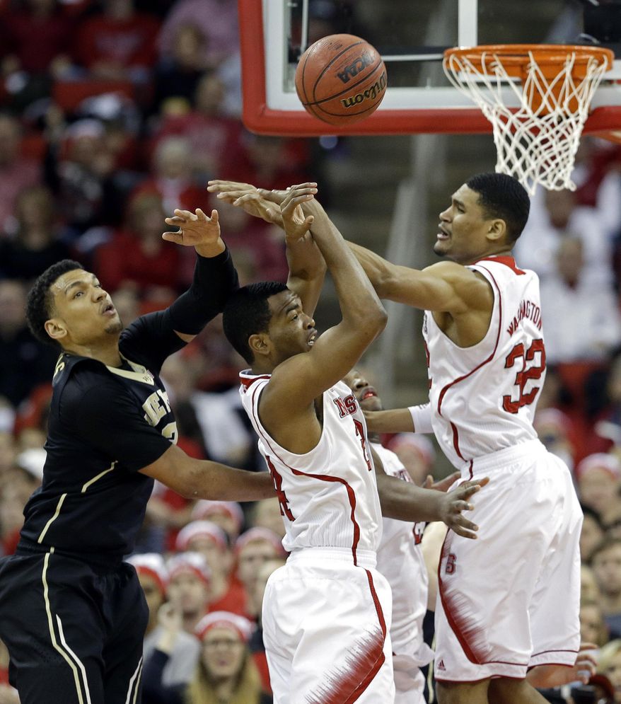 North Carolina State's T.J. Warren, center, and Kyle Washington (32) reach for the ball against Wake Forest's Devin Thomas during the second half of an NCAA college basketball game in Raleigh, N.C., Tuesday, Feb. 11, 2014. North Carolina State won 82-67. (AP Photo/Gerry Broome)
