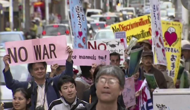 In this video image taken from AP video, protesters march against the relocation plan of the US base in Naha, OKinawa prefecture, Feb. 11, 2014.  Several hundred people rallied Tuesday against a contentious plan to relocate a U.S. military base to another site on Okinawa ahead of U.S. Ambassador Caroline Kennedy&#x27;s visit to the southern Japanese island. (AP Photo via AP video)