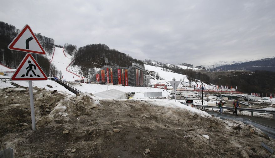 The lower slopes appear devoid of snow as brown, dirty snow is piled up on the road to the finish area of the alpine ski venue at the Sochi 2014 Winter Olympics, Tuesday, Feb. 11, 2014, in Krasnaya Polyana, Russia. Warm temperatures in the mountains was a factor in the cancellation of Women's downhill training on Tuesday. (AP Photo/Christophe Ena)