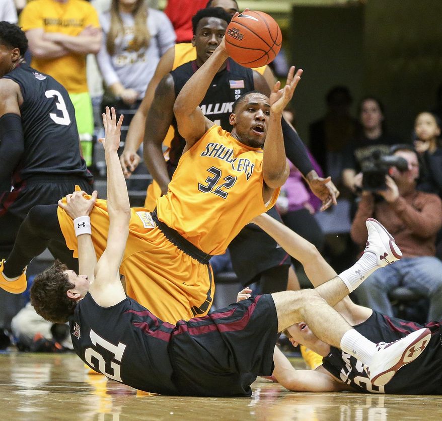 Wichita State's Tekele Cotton dishes the ball off after winning a loose ball against Southern Illinois' Tyler Smithpeters during the first half of an NCAA college basketball game Tuesday, Feb. 11, 2014, in Wichita, Kan. (AP Photo/The Wichita Eagle, Fernando Salazar) LOCAL TV OUT; MAGS OUT LOCAL RADIO OUT; LOCAL INTERNET OUT