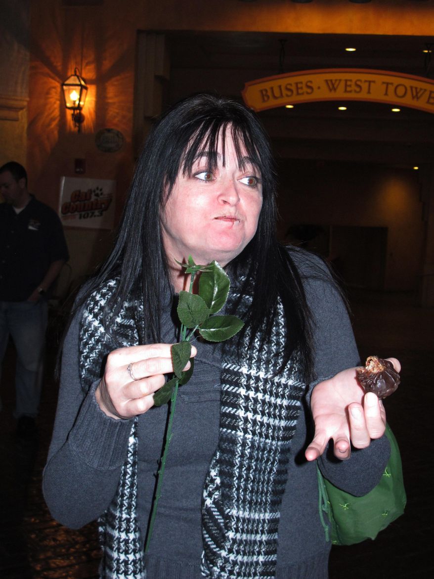 An unexpected wave of saltiness hits Melissa Ehrke of Egg harbor Township, N.J. as she tries chocolate-covered bacon strips shaped like a rose at the Tropicana Casino and Resort in Atlantic City, N.J. on Monday, Feb. 10, 2014. The casino's Bacon Week festival includes unusual offerings like bacon milk shakes, bacon cupcakes, bacon bloody Marys, beer, vodka and bourbon, and even bacon-flavored toothpaste, dental floss and lip balm. (AP Photo/Wayne Parry)