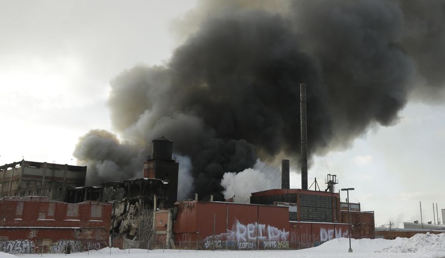 Smoke rises from a fire in an abandoned commercial building on Detroit's east side on Tuesday, Feb. 11, 2014. Battalion Chief Richard Wright says a firefighter was injured when he fell at least 10 feet from an aerial lift to ground after being hit by flying bricks. Wright says the six-story building has been burning for about a week and the department's strategy is to spray water on it whenever possible. (AP Photo/Carlos Osorio)