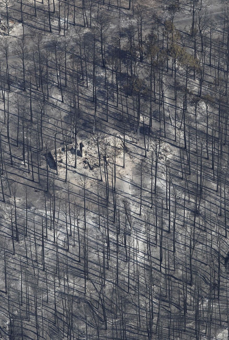 File - In this Sept. 7, 2011 file photo, a home destroyed by wildfire is seen among burned trees near Bastrop, Texas. Forestry officials say this year's wildfire threat will be highest in only some parts of Texas but even that danger isn't close to what happened three years ago when blazes burned more than 2,700 homes and blackening about 6,200 square miles (AP Photo/Eric Gay, File)