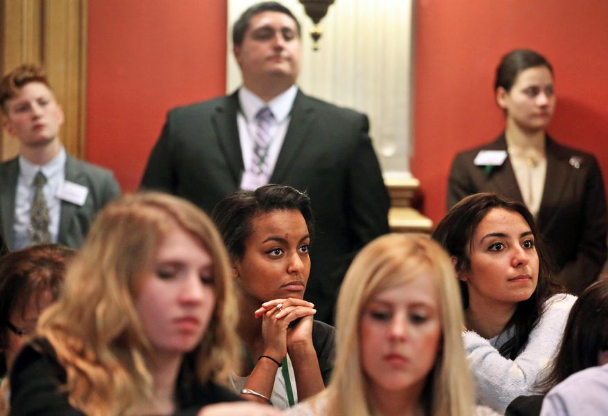 State Legislature interns Mahtub Zare Mochanloo, far right, and Sophanite Gedion, second row center, listen to testimony during a hearing on a bill which would allow Colorado public school teachers to carry concealed firearms during class, at the Capitol, in Denver, Tuesday, Feb. 11, 2014. The Republican proposal has been made before without success, but the suggestion has additional relevance after last year's Arapahoe High School shootings, in which a student targeted a teacher. (AP Photo/Brennan Linsley)