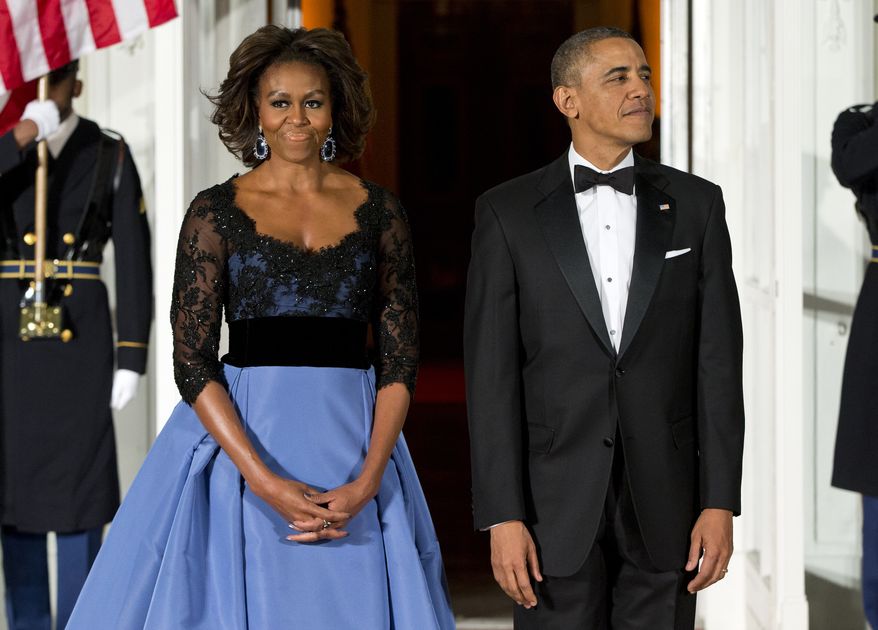 First lady Michelle Obama, left, and President Barack Obama wait for the arrival of French President François Hollande for a State Dinner at the North Portico of the White House on Tuesday, Feb. 11, 2014, in Washington. (AP Photo/ Evan Vucci)