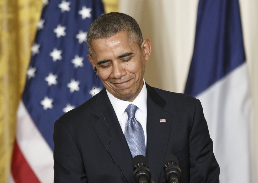 President Barack Obama smiles during his joint news conference with French President Francois Hollande, Tuesday, Feb. 11, 2014, in the East Room of the White House in Washington. Questions ranged from the conflict in Syria to the National Security Agency’s intelligence gathering operations and other issues shared between the U.S. and France/ (AP Photo/J. Scott Applewhite)