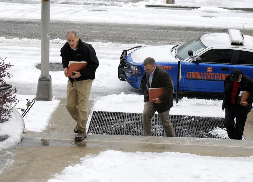 Charley English, left, head of the Georgia Emergency Management Agency, arrives at the Capitol in downtown Atlanta, Wednesday, Feb. 12, 204, for a briefing with Gov. Nathan Deal. An ice storm knocked out power to a large swath of the South, as Atlanta saw its second bout of snow in just over two weeks. (AP Photo/Christina A. Cassidy)