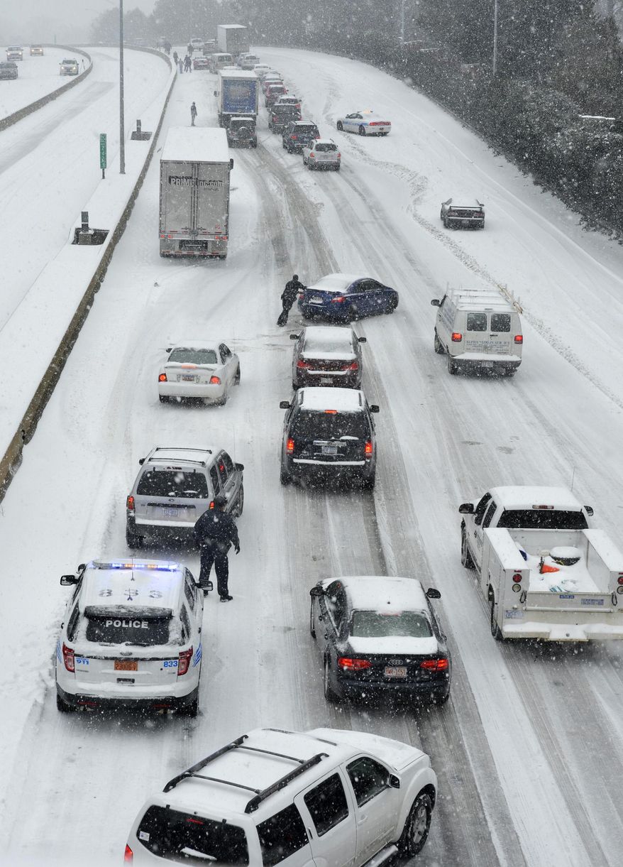 Traffic along Independence Boulevard near Hawthorne Lane crawls along the slick roadway as a winter storm hits Wednesday, Feb. 12, 2014, in Charlotte, N.C. (AP Photo/The Charlotte Observer, Davie Hinshaw) MAGS OUT; TV OUT; NEWSPAPER INTERNET ONLY