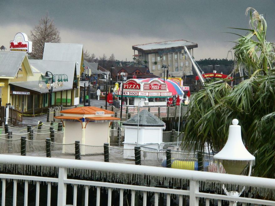 Ice coats trees and railings at the popular Broadway at the Beach tourist attraction in Myrtle Beach, S.C., on Wednesday, Feb. 12, 2014 as a winter storm moves through South Carolina. The storm caused numerous traffic accidents and cut electric power to tens of thousands statewide. (AP Photo/Bruce Smith)
