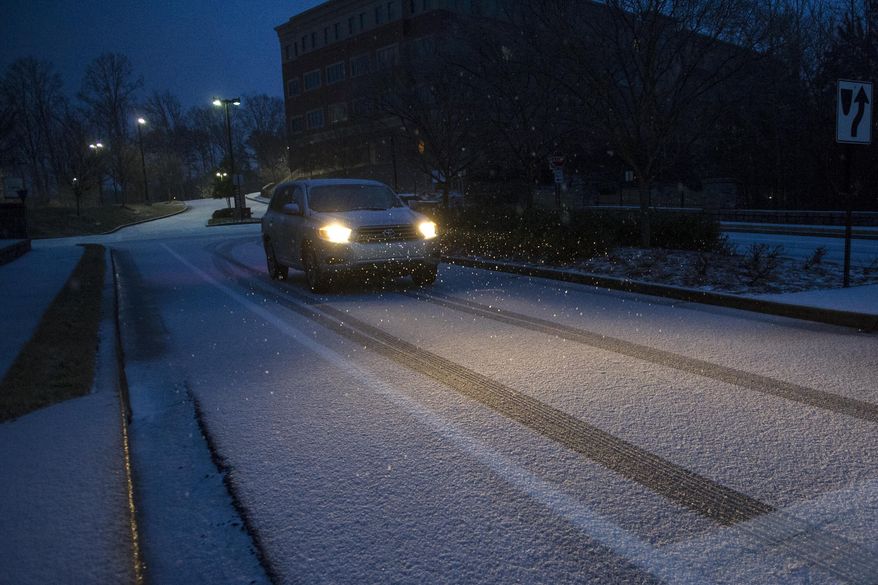 A motorist drives on a street covered with snow and ice as a winter storm begins to roll through on Wednesday, Feb. 12, 2014, in Johns Creek, Ga. Across the South, winter-weary residents woke up Wednesday to a region encased in ice, snow and freezing rain, with forecasters warning that the worst of the potentially "catastrophic" storm is yet to come. From Texas to the Carolinas and the South's business hub in Atlanta, roads were slick with ice, tens of thousands were without power, and a wintry mix fell in many areas. (AP Photo/John Amis)