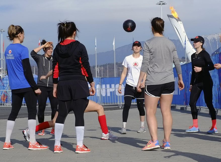 Members of the Canadian women's ice hockey team warm up outside before their game against the United States during the 2014 Winter Olympics women's ice hockey tournament at Shayba Arena, Wednesday, Feb. 12, 2014, in Sochi, Russia. (AP Photo/J. David Ake)