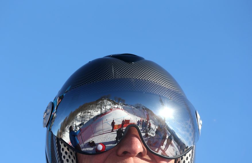The men's downhill ski course is reflected in ski goggles at the Alpine ski venue at the Sochi 2014 Winter Olympics, Wednesday, Feb. 12, 2014, in Krasnaya Polyana, Russia. (AP Photo/Luca Bruno)