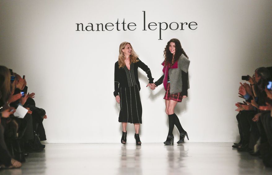 Fashion designer Nanette Lepore, left, brings her daughter, Violet, on the runway after showing her Fall 2014 collection during New York Fashion Week on Wednesday Feb. 12, 2014. (AP Photo/Bebeto Matthews)