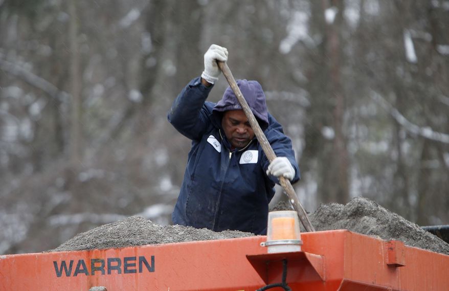 Fort Payne Public Works employee Carl Prater uses a shovel to shift sand in the bed of his sand truck as they sand area roads Wednesday Feb. 12, 2014 in Fort Payne Ala. A winter storm warning covered almost the entire northern half of the state, and many schools and businesses were closed or opened late. (AP Photo/Hal Yeager)
