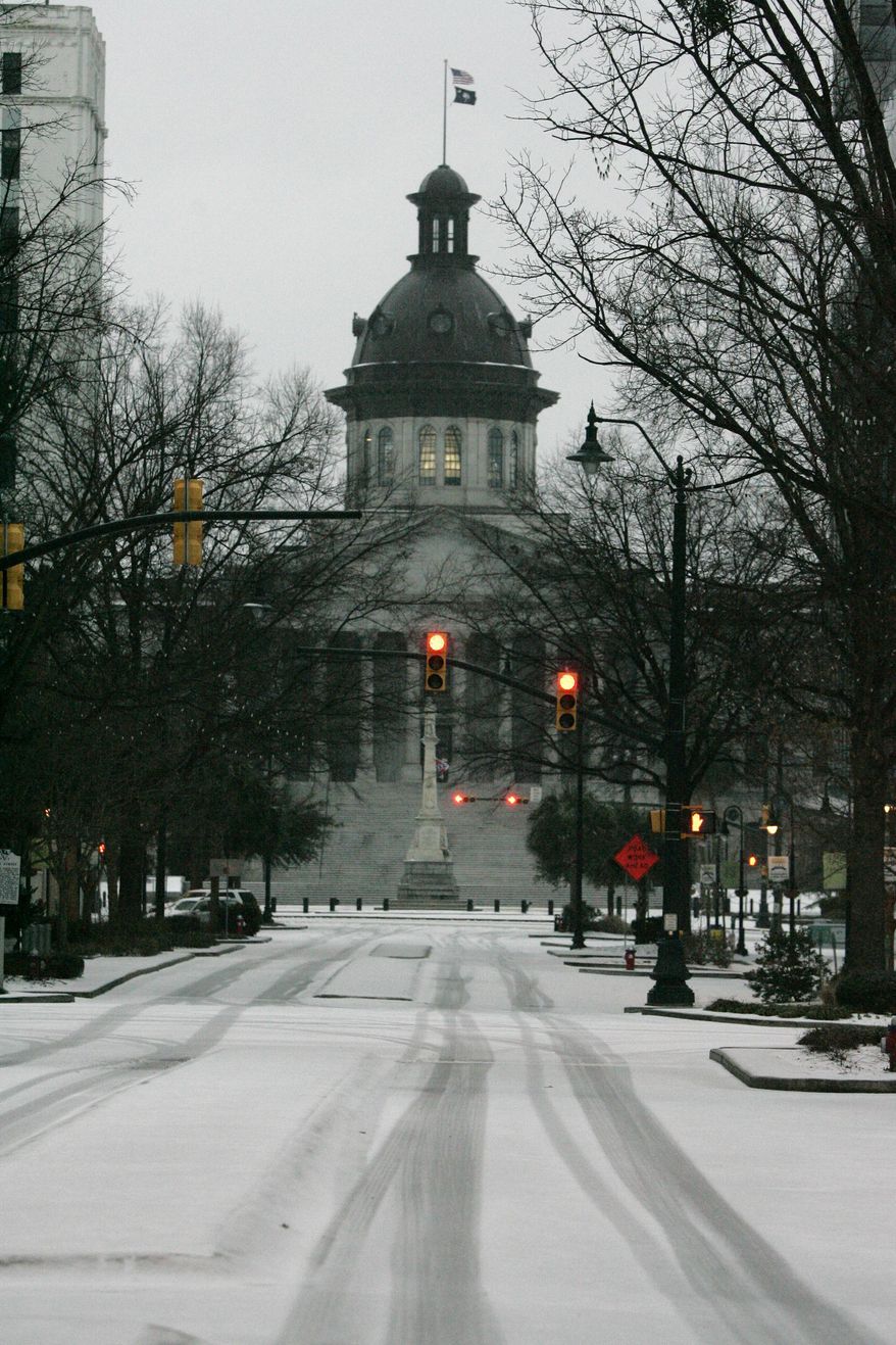 Ice and snow cover Main Street at the Statehouse in Columbia, S.C., early Wednesday, Feb. 12, 2014. Gov. Nikki Haley again declared a state of emergency as emergency officials worried that as much as an inch of ice accumulating on trees and power lines Wednesday into Thursday could knock out powers to thousands, especially in the Midlands. (AP Photo/Mary Ann Chastain)