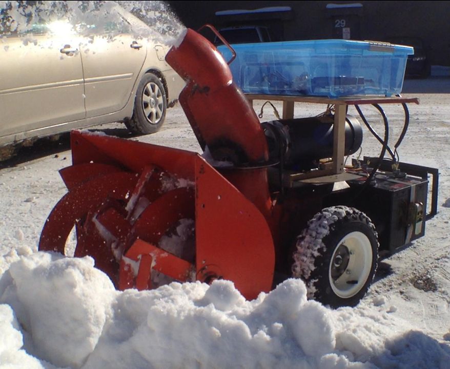 Snow shoots out of a remotely-controlled snowblower in the parking lot of Wausau West High School in Wausau, Wis. on Thursday, Feb. 6, 2014. The device is being developed by a team of 13 students at the high school through a grant from MIT and the Lemmelson Foundation. The team hopes to turn it into an autonomous device. (AP Photo/The Wausau Daily Herald, Keith Uhlig)