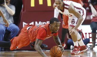 Texas Tech guard Jamal Williams, Jr. dives for a loose ball in front of Oklahoma guard Jordan Woodard during the first half on an NCAA college basketball game in Norman, Okla., Wednesday, Feb. 12, 2014. (AP Photo/Sue Ogrocki)