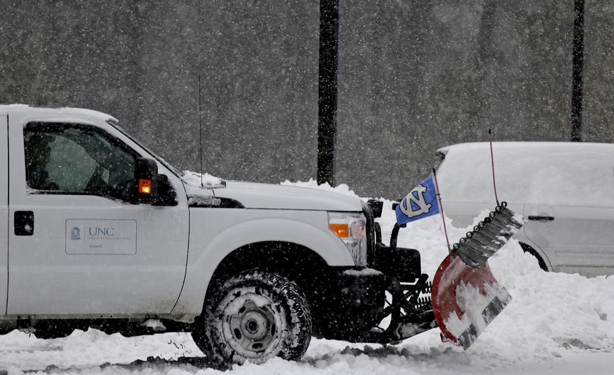 A university worker plows the parking lot outside the Dean E. Smith Center at the University of North Carolina in Chapel Hill, N.C., Wednesday, Feb. 12, 2014 prior to a basketball game between Duke and North Carolina. A major winter slammed into North Carolina Wednesday, turning homebound commutes that typically take minutes into hours-long ordeals as traffic slowed to a slippery slog and threatening to leave many areas dark because of power outages. (AP Photo/Gerry Broome)