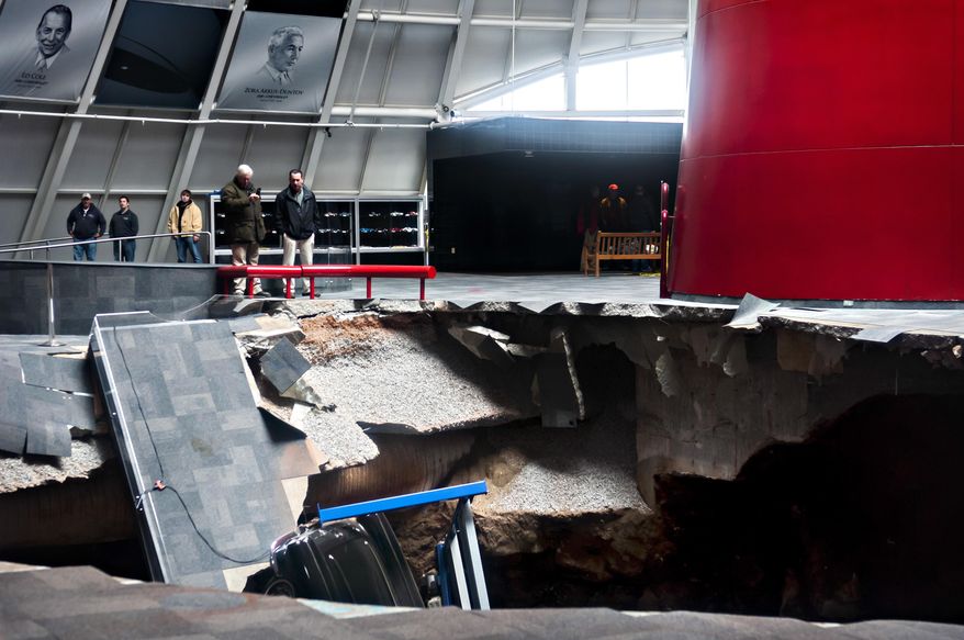 Officials view a sinkhole that opened up in the Skydome showroom, Wednesday, Feb. 12, 2014, at the National Corvette Museum in Bowling Green, Ky. Eight display cars were swallowed by the hole. (AP Photo/Daily News, Miranda Pederson)