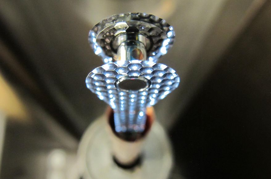 This undated image provided by the Lawrence Livermore National Laboratory shows a cylindrical hohlraum container about 0.4 inches tall containing a deuterium and tritium capsule, held by cryogenically-cooled positioning arms. In research reported Wednesday, Feb. 12, 2014 by the journal Nature, scientists say they've taken a key step toward harnessing nuclear fusion as a new way to generate power, an idea that has been pursued for decades. In tests, 192 laser beams briefly fired into the small gold cylinder which held the two kinds of hydrogen. The energy from the lasers kicked off a process that compressed the ball by an amount akin to squeezing a basketball down to the size of a pea, said Debbie Callahan, an author of the paper. That created the extremely high pressure and temperatures needed to get the hydrogen atoms to fuse. (AP Photo/Lawrence Livermore National Laboratory, Eddie Dewald)